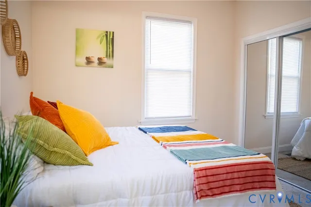 a bedroom with a bed and next to a window