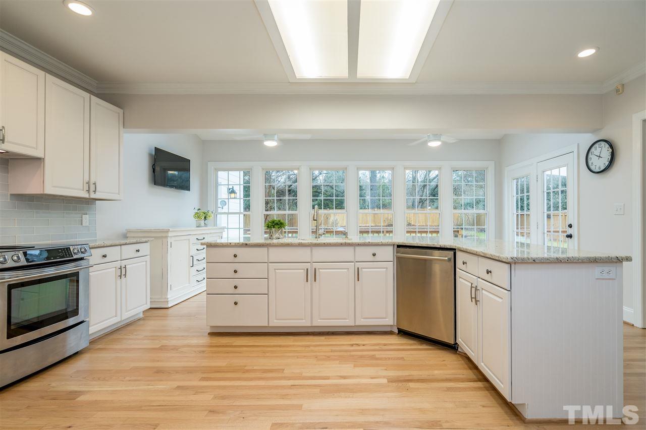 6916 Darcy Lane Raleigh, NC 27606 - Photo 7 of 30 Updated white kitchen with granite, new appliances.