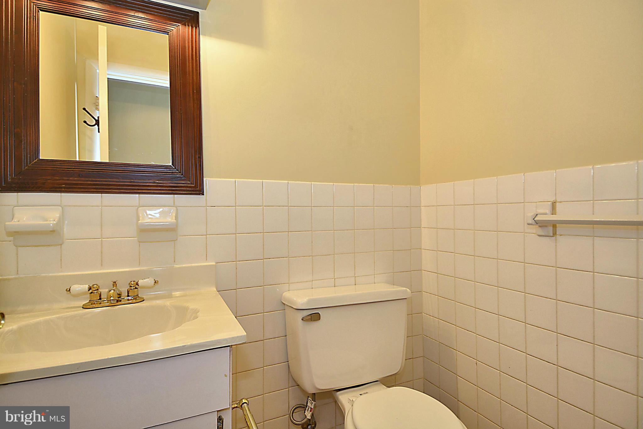 7421 Blair Road Northwest, Unit 7421 Washington, DC 20012 - Photo 14 of 27 a bathroom with a sink mirror toilet and window