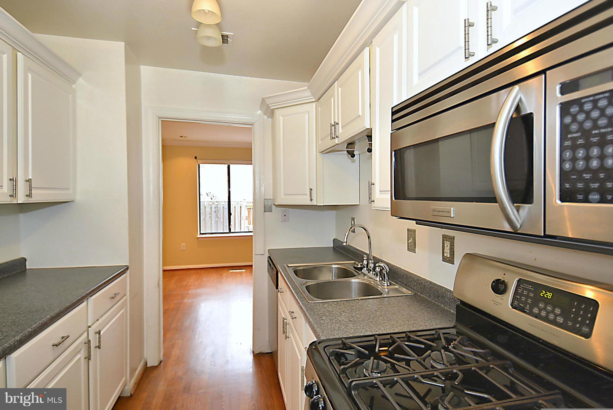 7421 Blair Road Northwest, Unit 7421 Washington, DC 20012 - Photo 6 of 27 a kitchen with stainless steel appliances a stove a sink and a microwave