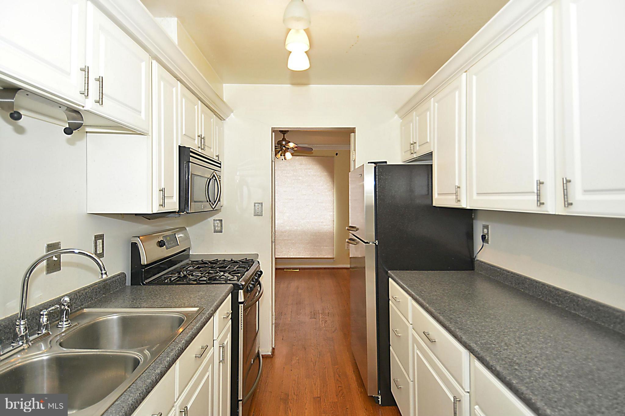 7421 Blair Road Northwest, Unit 7421 Washington, DC 20012 - Photo 7 of 27 a kitchen with stainless steel appliances granite countertop a sink stove and refrigerator