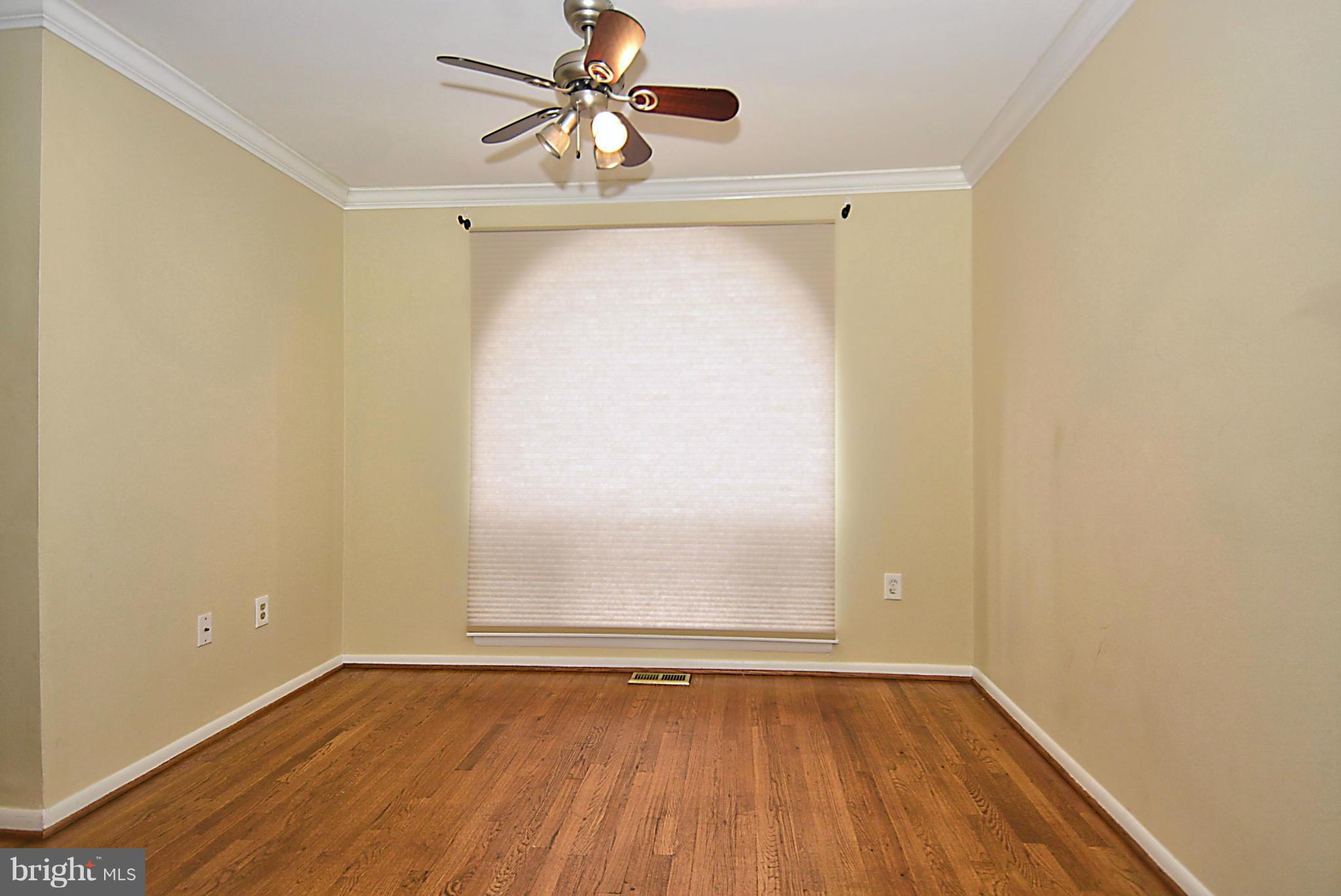 7421 Blair Road Northwest, Unit 7421 Washington, DC 20012 - Photo 8 of 27 an empty room with wooden floor fan and windows
