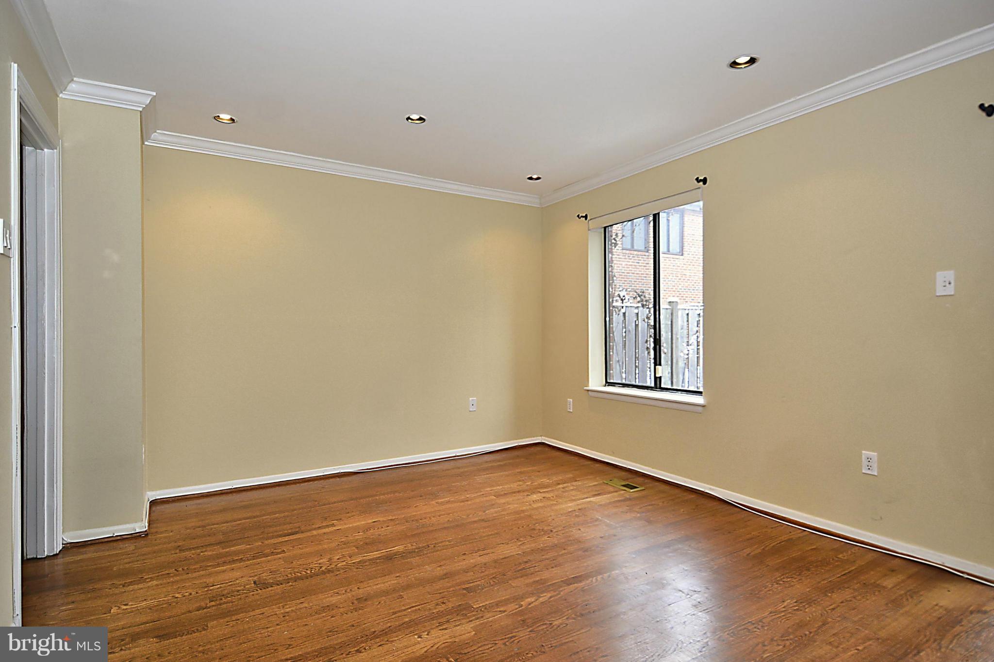 7421 Blair Road Northwest, Unit 7421 Washington, DC 20012 - Photo 10 of 27 a view of an empty room with wooden floor and a window