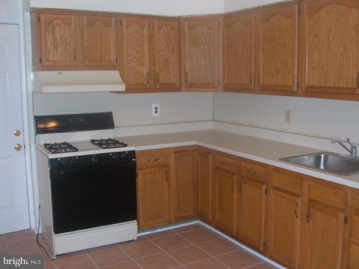 3936 Spring Garden Street Philadelphia, PA 19104 - Photo 2 of 7 a kitchen with a sink and cabinets
