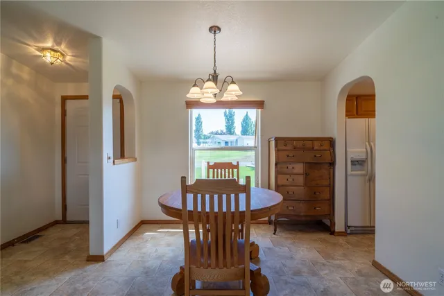 a view of a dining room with furniture a chandelier and wooden floor
