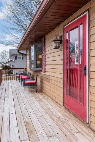 a roof deck with table and chairs and wooden floor