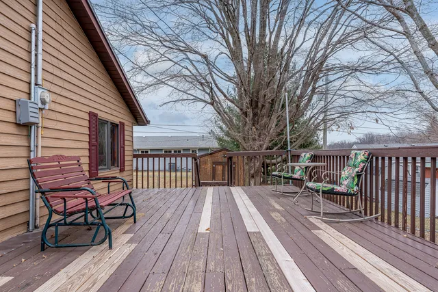 a view of a house with wooden deck and furniture