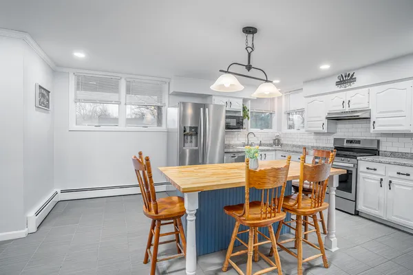 a dining room with stainless steel appliances kitchen island granite countertop a table and chairs