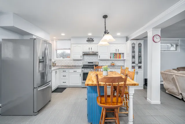 a kitchen with stainless steel appliances kitchen island granite countertop a refrigerator and microwave