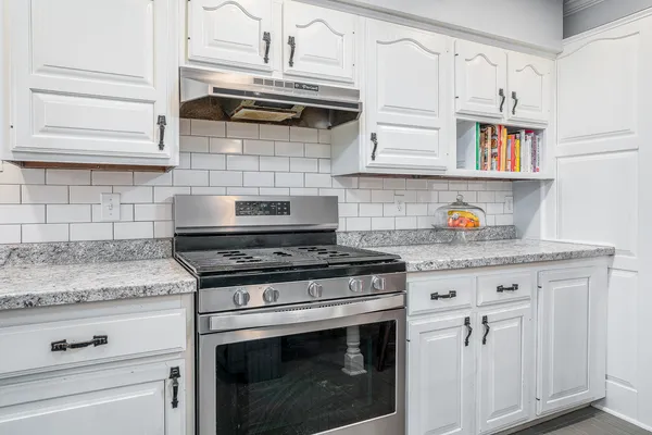 a stove top oven sitting inside of a kitchen