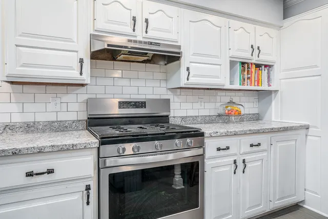 a stove top oven sitting inside of a kitchen