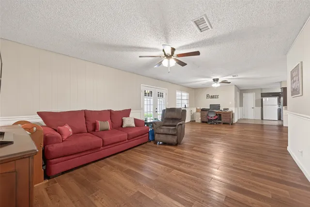 a living room with furniture and a wooden floor