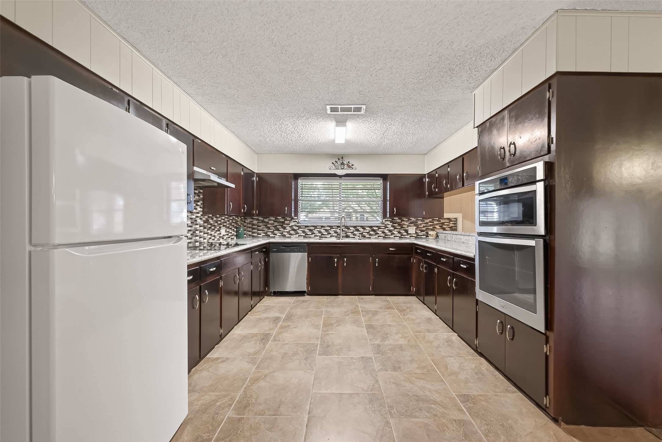 9525 Gene Street Needville, TX 77461 - Photo 15 of 48 a large kitchen with cabinets and stainless steel appliances