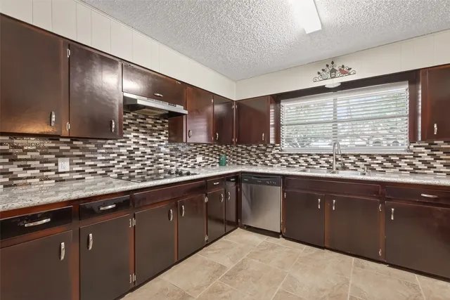 a kitchen with stainless steel appliances granite countertop a sink and wooden cabinets