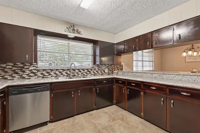 a kitchen with granite countertop sink cabinets and stainless steel appliances