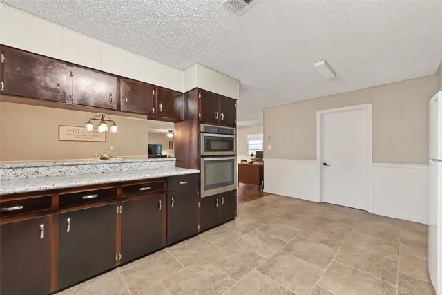 a kitchen with granite countertop a stove and cabinets
