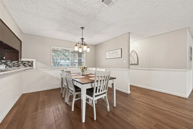a view of a dining room with furniture a chandelier and wooden floor