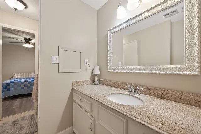 a bathroom with a granite countertop sink and a mirror