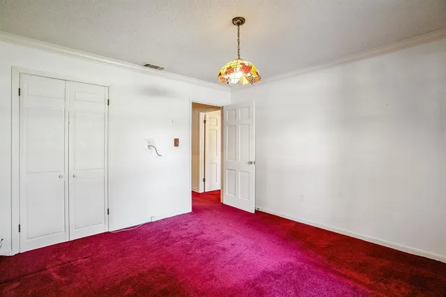 a view of an empty room with a chandelier fan