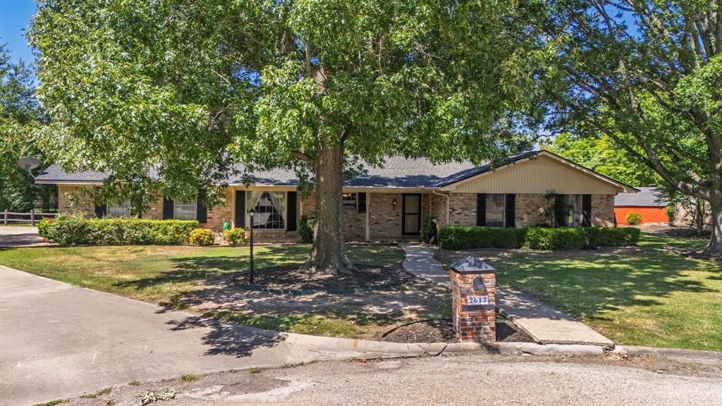 2617 Park Street Commerce, TX 75428 - Photo 26 of 34 a front view of a house with a garden
