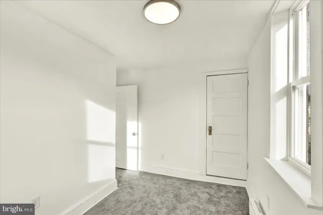 an empty room with windows and closet