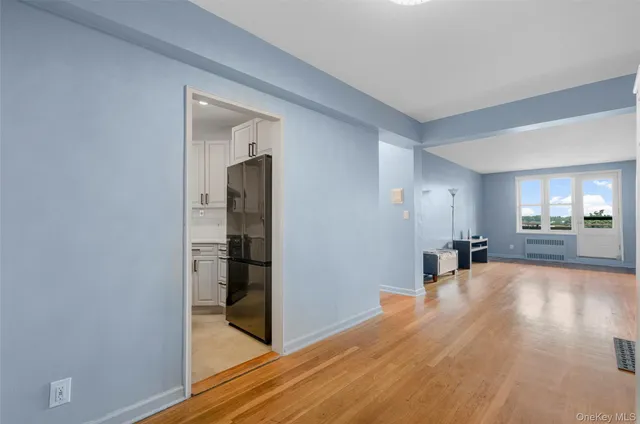 a view of a livingroom with wooden floor and a bathroom