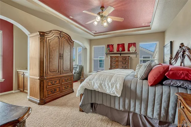 a spacious bedroom with a bed and a chandelier