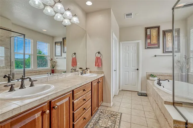a spacious bathroom with a tub shower and a sink