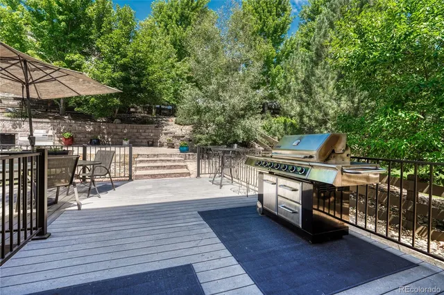 a view of a patio with table and chairs potted plants and large tree