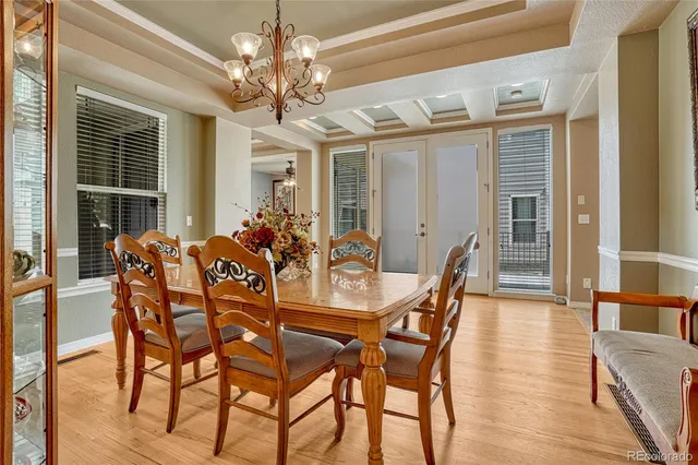 a dining room with furniture a chandelier and wooden floor