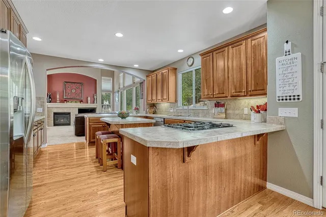 a kitchen with kitchen island granite countertop wooden cabinets a stove and a sink