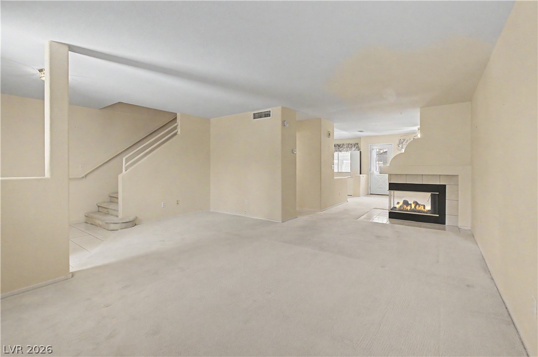 2243 Rugged Mesa Drive Laughlin, NV 89029 - Photo 12 of 32 A spacious living room featuring a cozy fireplace and stairs leading to additional levels.
