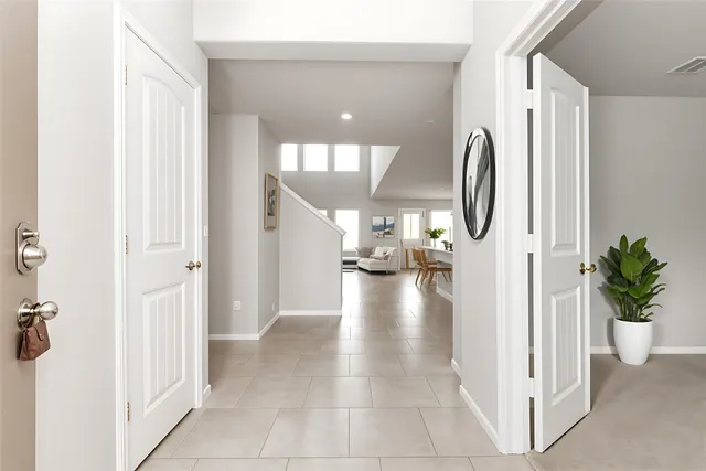 a view of a hallway with dining area and chandelier