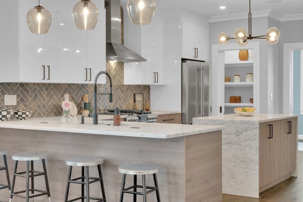 87 Parkton Road, Unit 3 Boston, MA 02130 - Photo 2 of 38 a kitchen with stainless steel appliances kitchen island granite countertop a table chairs in it and wooden floors