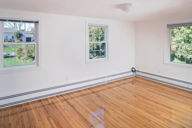a view of a room with wooden floor and a window