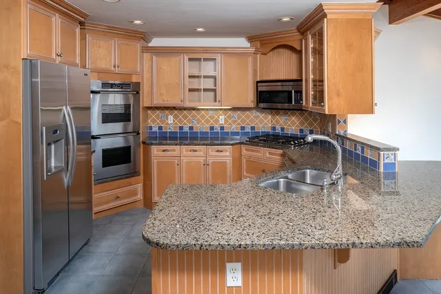 a kitchen with stainless steel appliances granite countertop a sink refrigerator and microwave