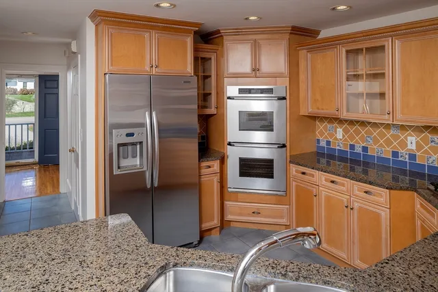 a kitchen with stainless steel appliances granite countertop a refrigerator and a stove