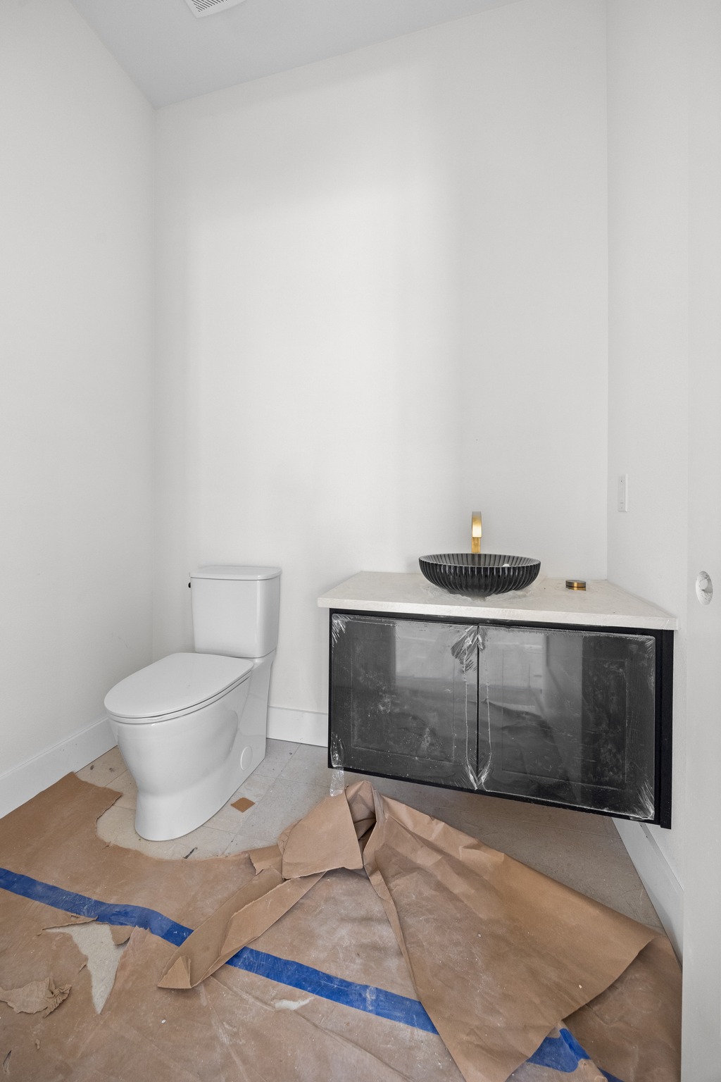 903 Flint Ridge Trail Georgetown, TX 78628 - Photo 14 of 39 Modern bathroom featuring a floating black vanity with a light-toned countertop, a black vessel sink, and a gold-toned wall-mounted faucet