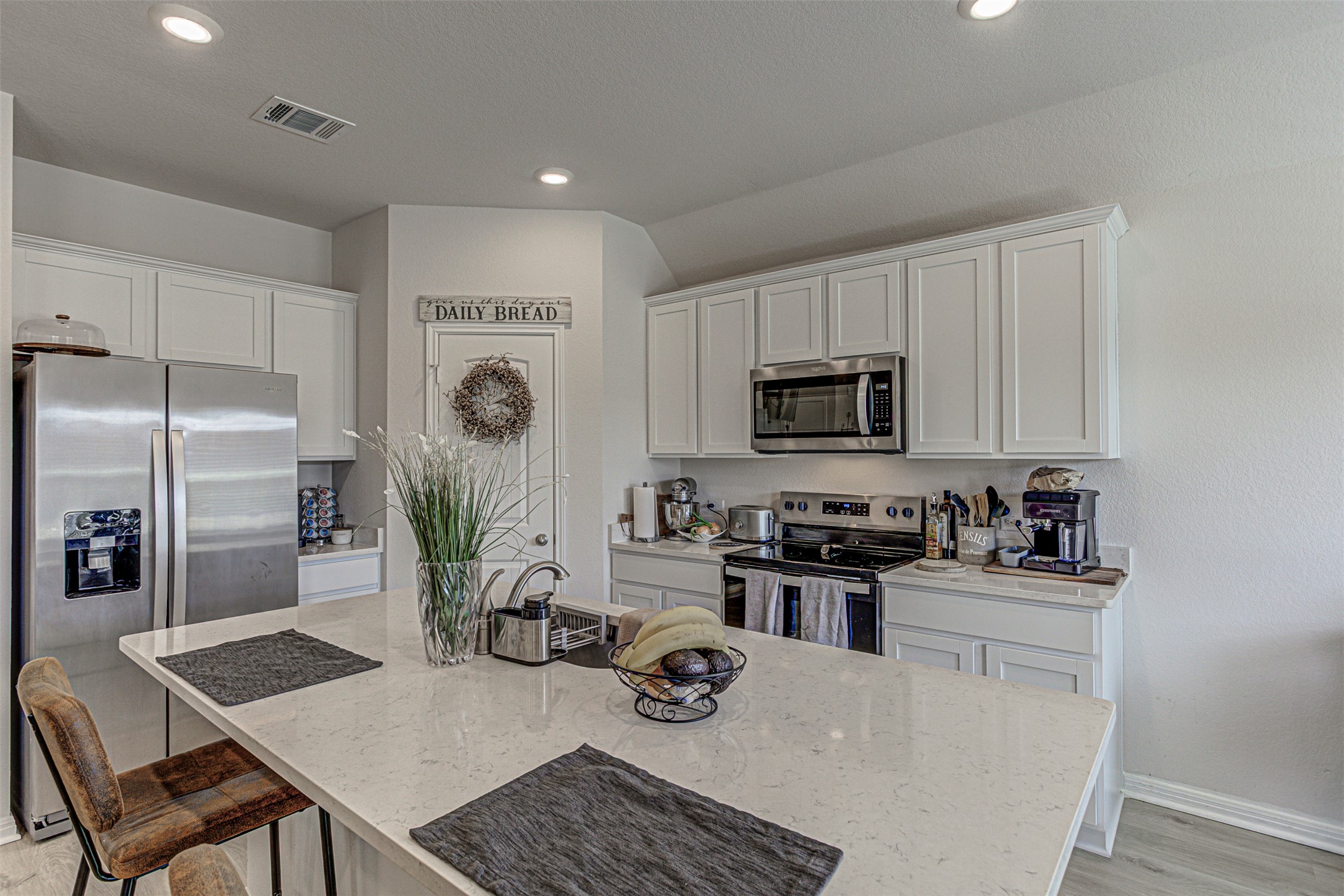309 Lone Cedar Road Marble Falls, TX 78654 - Photo 13 of 35 Kitchen with stainless steel appliances, white cabinetry, light stone counters, a kitchen bar, and a center island with sink