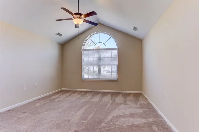 an empty room with a window and a fan
