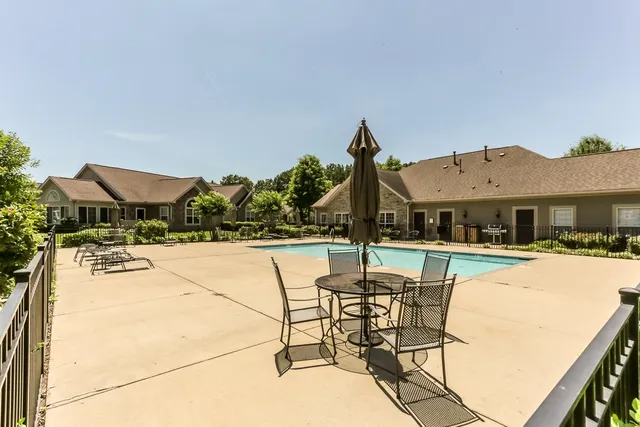 a view of a house with swimming pool and sitting area