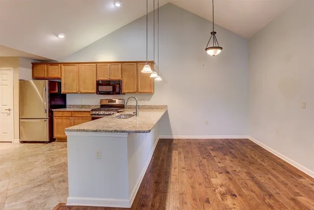a kitchen with kitchen island a sink stainless steel appliances and cabinets