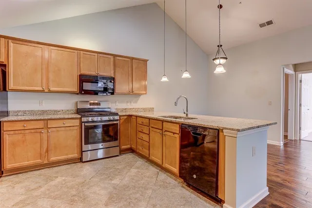 a kitchen with stainless steel appliances granite countertop a stove a sink and a microwave