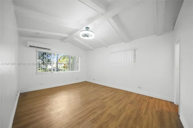 a view of an empty room with a chandelier fan