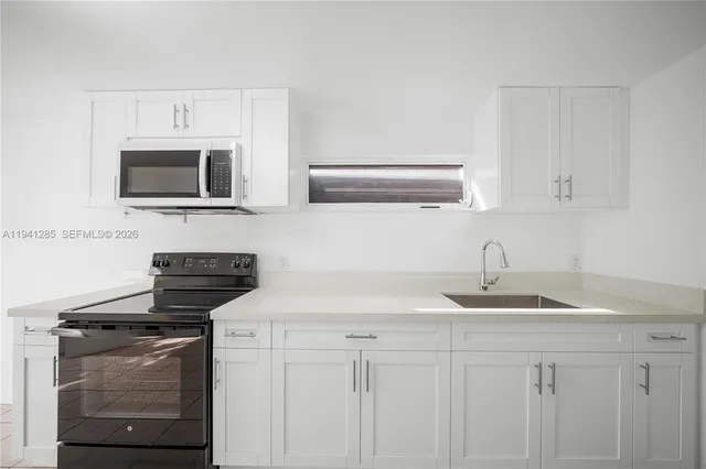 a kitchen with granite countertop a stove and a microwave