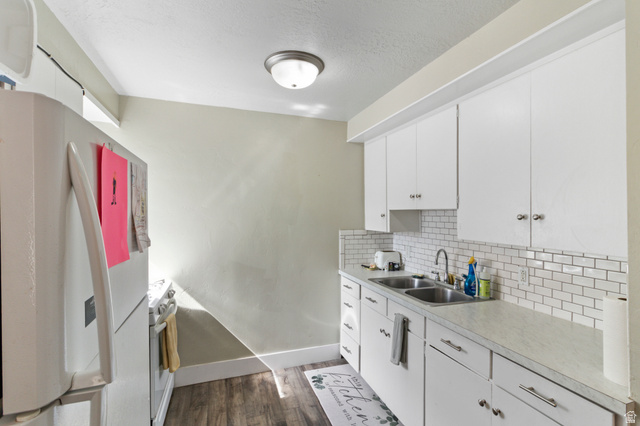 386 North 500 East Provo, UT 84606 - Photo 10 of 24 Kitchen featuring white appliances, white cabinets, light countertops, dark wood-type flooring, and a textured ceiling
