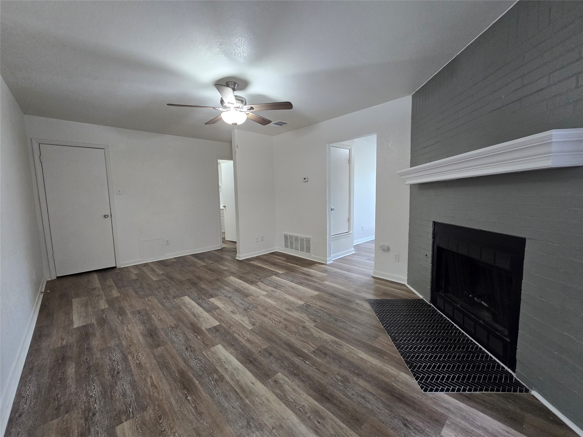 2003 Kenneth Avenue, Unit B Austin, TX 78741 - Photo 7 of 19 Rich wood-look flooring anchors this inviting space accented by a classic brick fireplace.