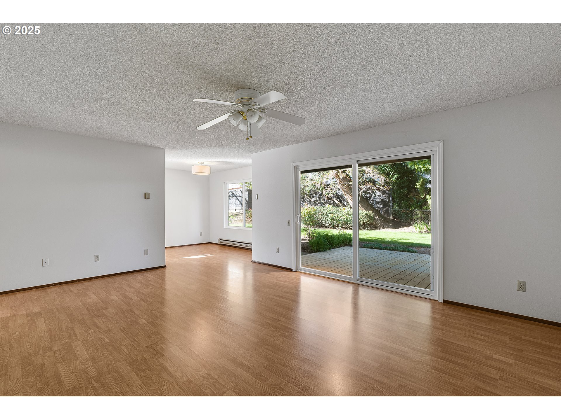 10915 Southwest Meadowbrook Drive, Unit 22 Portland, OR 97224 - Photo 11 of 23 a view of an empty room with wooden floor and a window