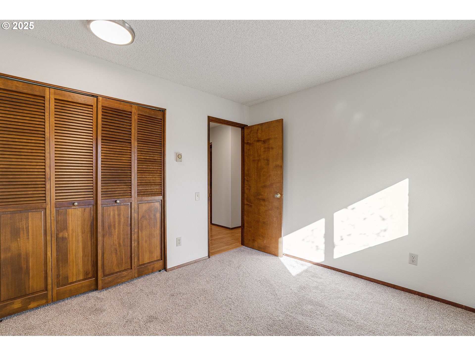 10915 Southwest Meadowbrook Drive, Unit 22 Portland, OR 97224 - Photo 13 of 23 a view of an empty room with wooden floor