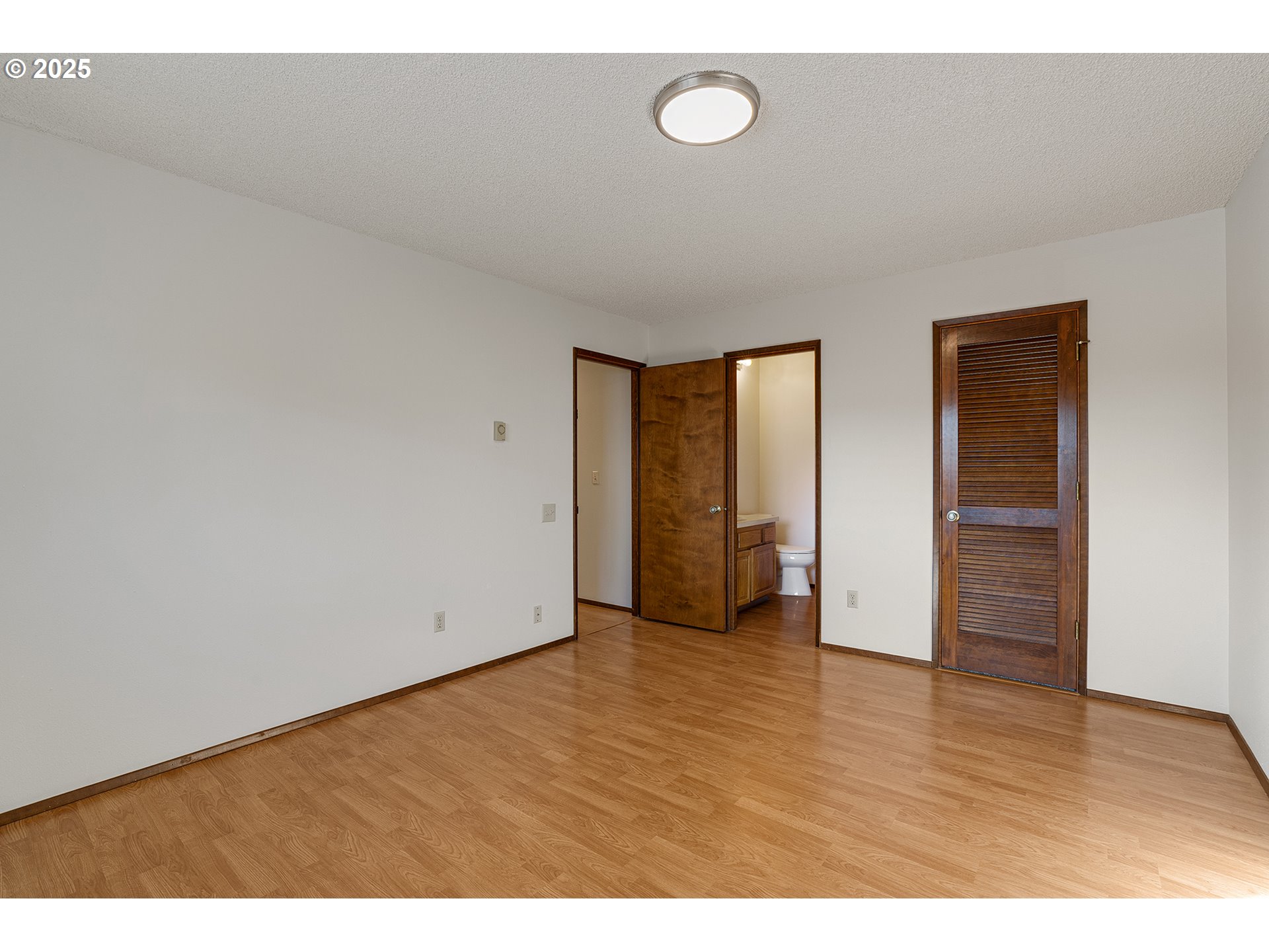 10915 Southwest Meadowbrook Drive, Unit 22 Portland, OR 97224 - Photo 15 of 23 a view of an empty room with wooden floor and closet